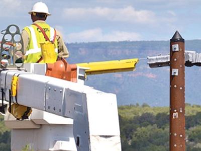 Lineman inspecting a steel utility pole